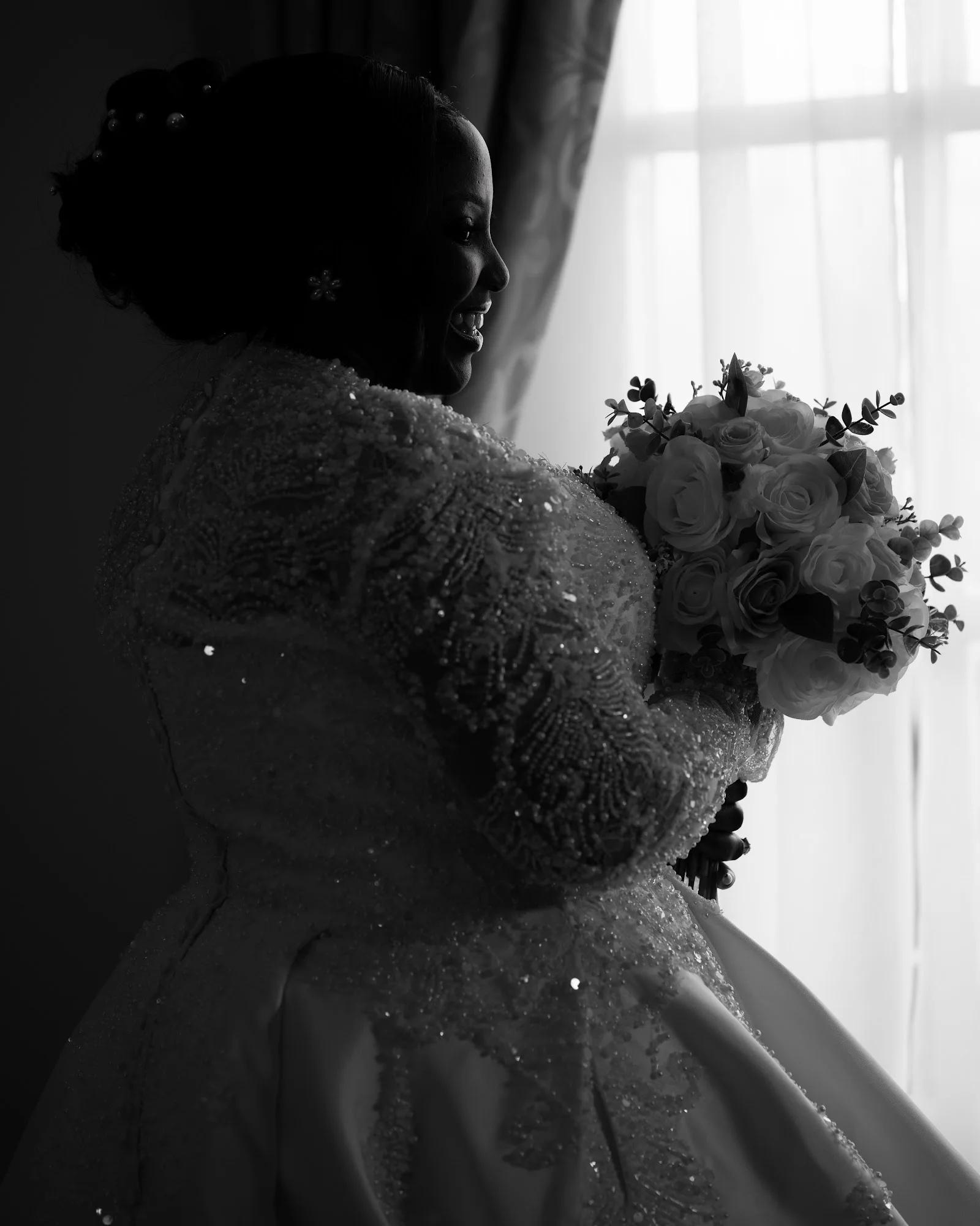 A bride holding her bouquet in silhouette