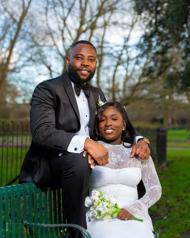 A groom sitting beside the bride in a garden