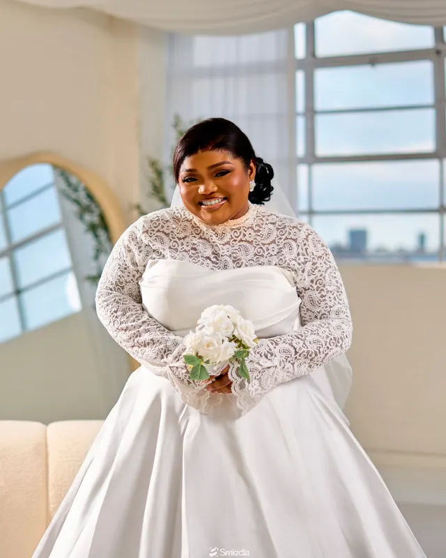Precious holding her bouquet by a window